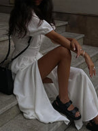 Robe longue chemise ajustée en coton, avec taille cintrée et fente avant pour un look élégant et confortable.