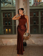 Robe longue à col halter en tissu léger, présente des découpes élégantes et un drapé fluide pour un look raffiné.