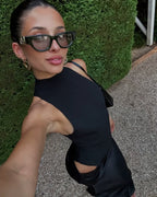 Robe longue en tissu léger, col halter, découpes latérales, et drapé fluide pour une silhouette élégante.