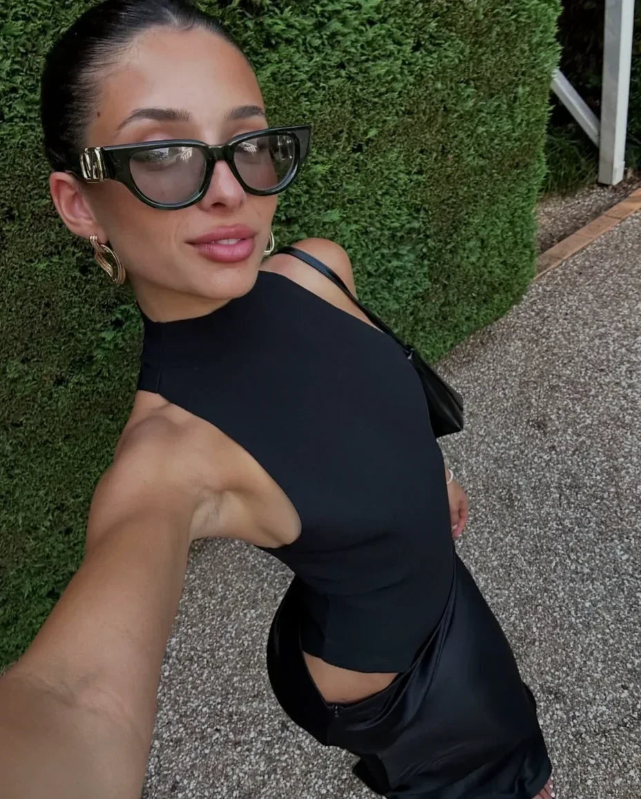 Robe longue en tissu léger, col halter, découpes latérales, et drapé fluide pour une silhouette élégante.