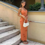 Robe longue corail à motifs floraux, en tissu léger, coupe ajustée, avec décolleté dos nu, parfaite pour l'été.