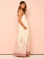 Robe longue en crème avec broderie florale, bretelles fines et tissu léger, parfaite pour l'été.