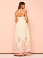 Robe longue en crème avec broderie florale, fines bretelles, idéale pour l'été, en tissu léger et aéré.