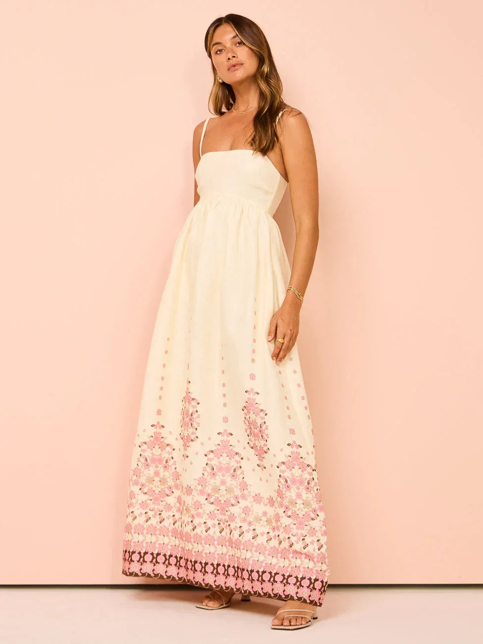 Robe longue crème en coton avec broderie florale et bretelles fines, parfaite pour l'été. Style léger et aérien.