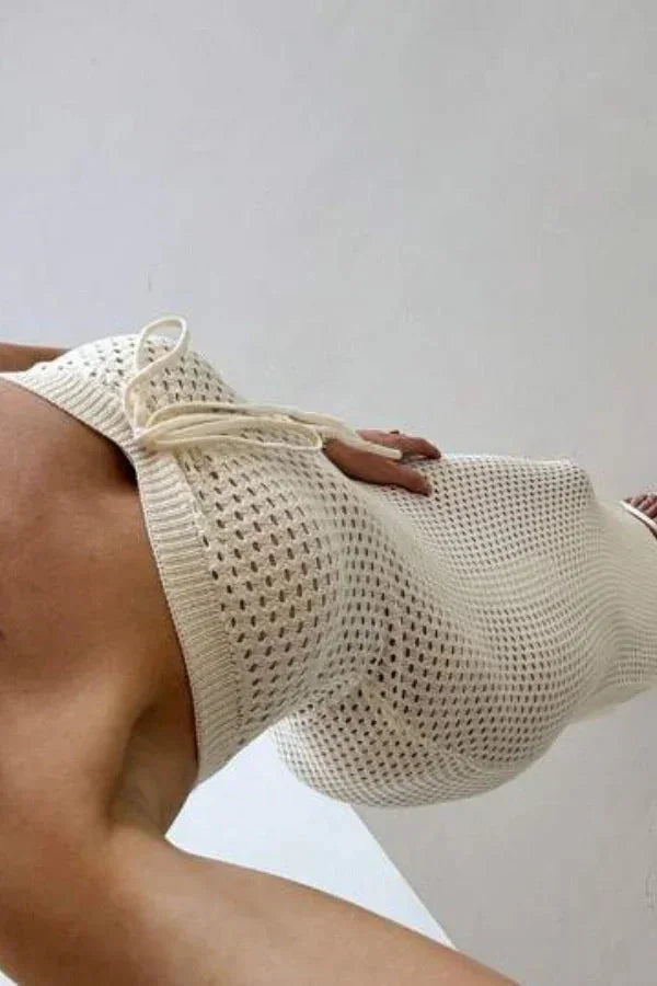 Robe longue sans manches en crochet crème, ajustée avec motif élégant, idéale pour un look estival décontracté.