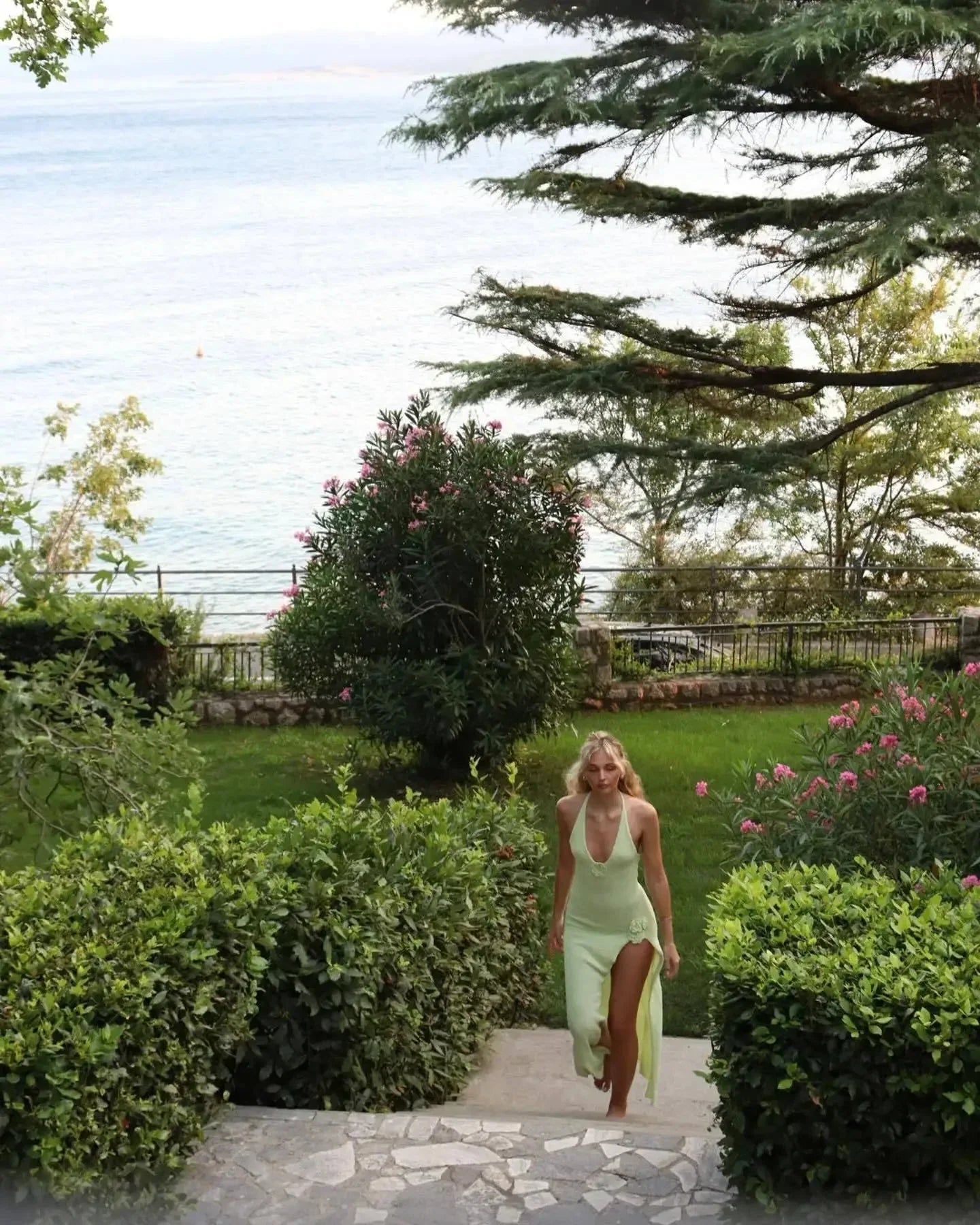 Robe longue dos nu en tissu léger avec appliqué floral et fente, idéale pour les journées d'été ensoleillées.