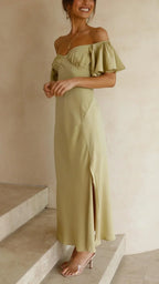 Robe longue fluide, épaules dénudées, fente sur le côté, idéale pour les soirées d'été, confectionnée en tissu léger.