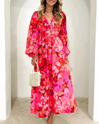 Robe longue fleurie à manches longues, col en V, en tissu fluide, taille cintrée, idéale pour mariage au printemps.