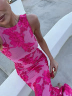 Robe longue fleurie rose sans manches, en tissu léger, offrant un style délicat et fluide pour les soirées d'été.