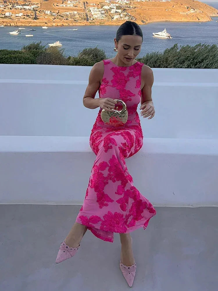 Robe longue fleurie rose sans manches, en tissu léger, avec un motif floral délicat et une longueur maxi pour les soirées.