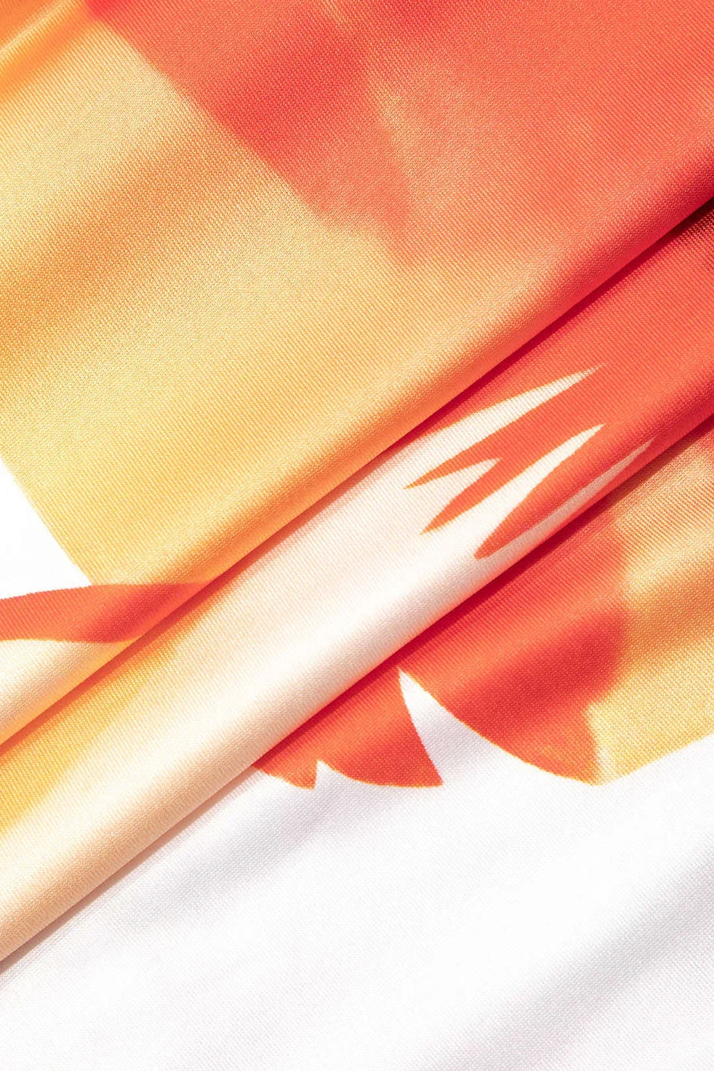 Robe longue fleurie blanche et orange sans bretelles, en tissu léger et estival, idéale pour les journées ensoleillées.