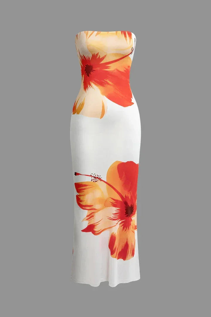 Robe longue fleurie sans bretelles, blanche et orange, en tissu léger idéal pour l'été, avec un design floral vibrant.