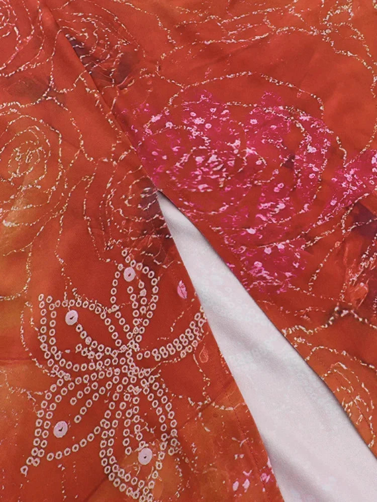 Robe longue rouge à fleurs avec dos nu, col licou et découpes, en tissu léger, idéale pour les soirées d'été.