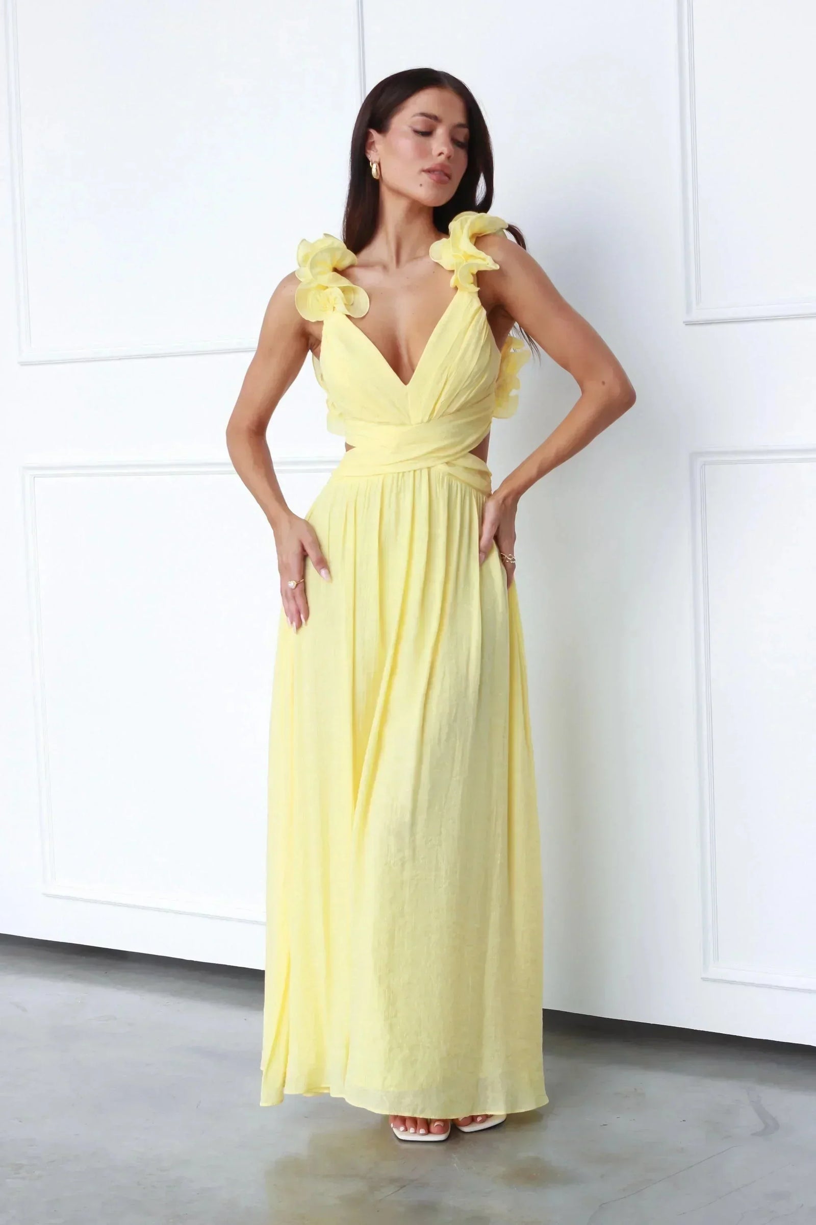 Robe longue jaune sans manches, col en V, tissu fluide avec motifs floraux, idéale pour un look estival décontracté.