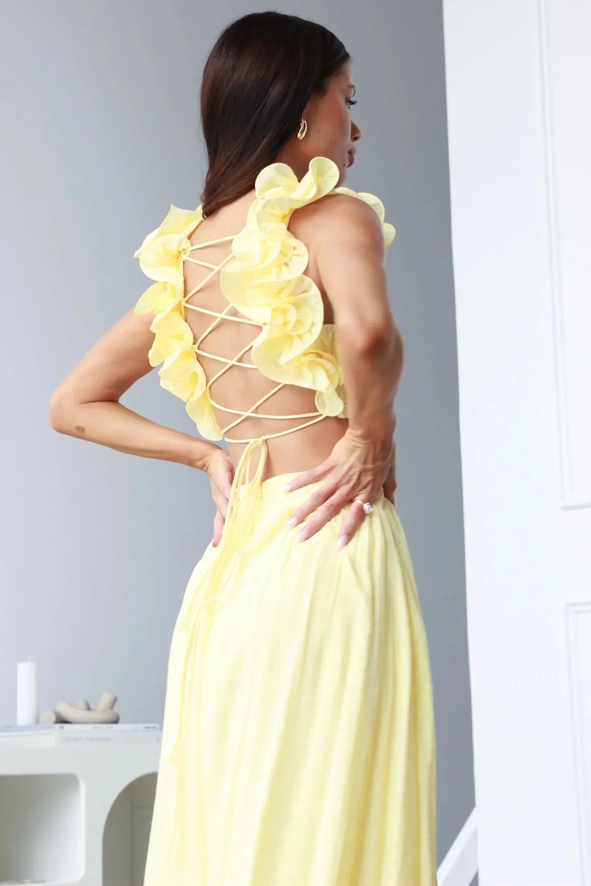 Robe longue jaune sans manches en tissu fluide, col en V et accents floraux, idéale pour les journées estivales.