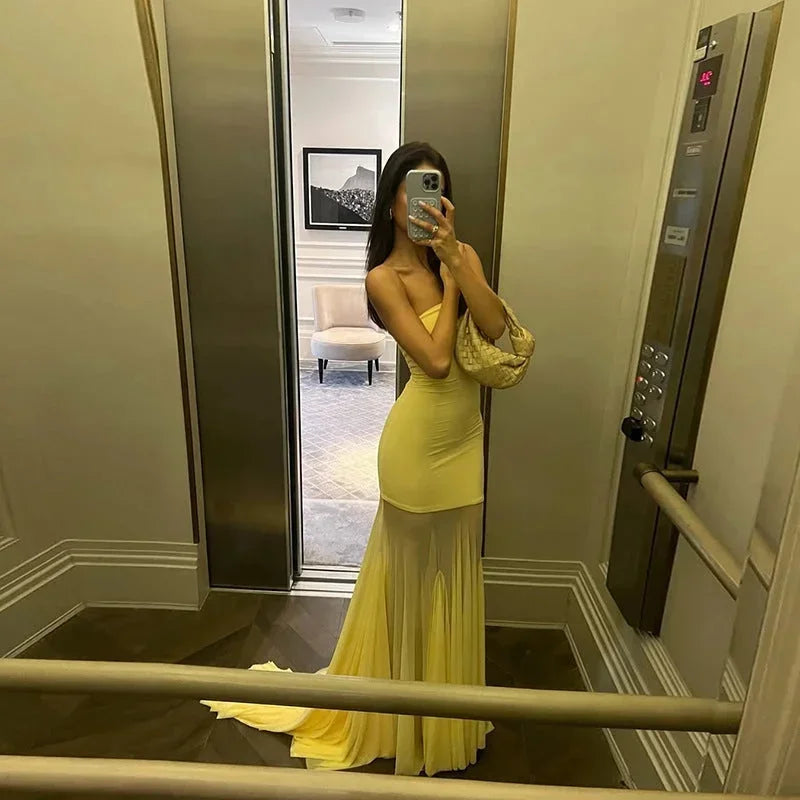 Robe longue jaune sans bretelles, en tissu fluide avec une jupe transparente, idéale pour les soirées d'été.