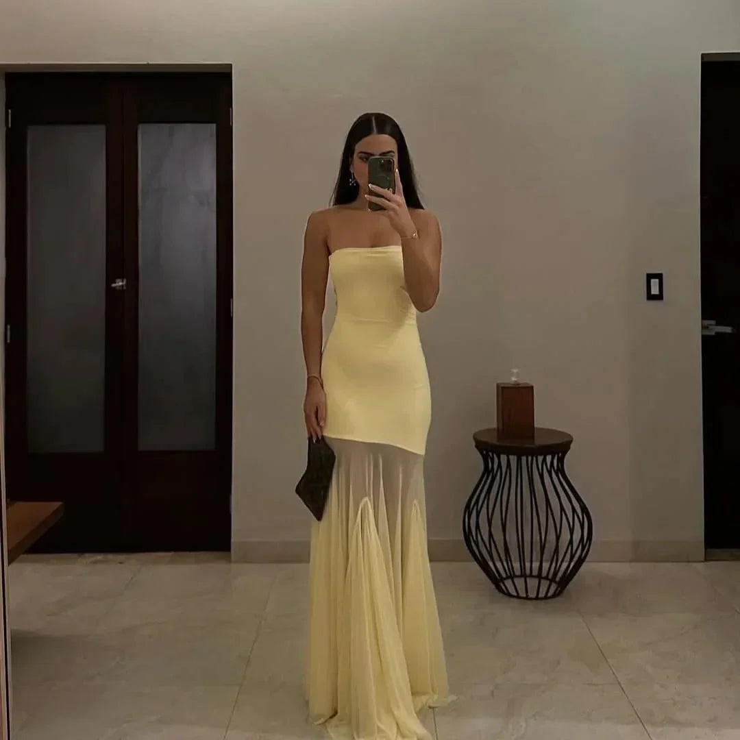 Robe longue jaune sans bretelles, fluide, avec jupe transparente, idéale pour des soirées élégantes et estivales.