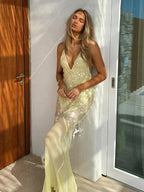 Robe longue jaune transparente avec sequins, dos nu croisé, col en V, idéale pour les soirées estivales.