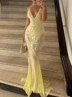 Robe longue jaune en tissu transparent, sequins scintillants, dos nu croisé et col en V pour soirées estivales.