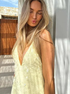 Robe longue jaune en tissu transparent, sequins brillants, dos nu croisé et col en V, idéale pour les soirées d'été.