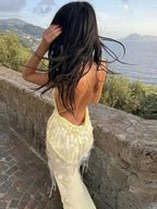 Robe longue jaune transparente en tissu léger, avec sequins, dos nu croisé et col en V, idéale pour les soirées d'été.