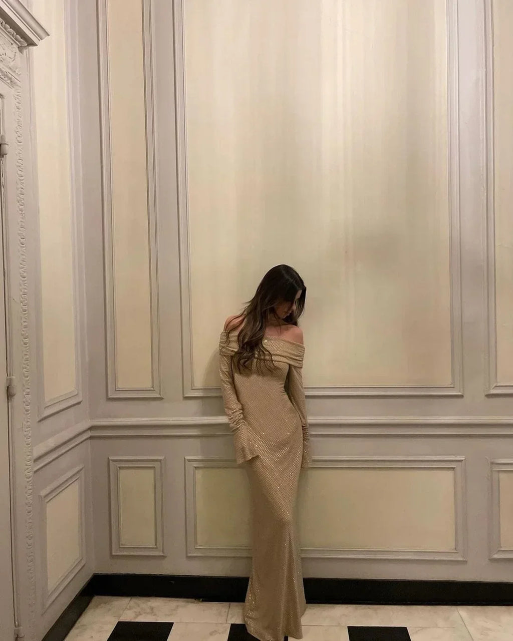 Robe longue longue scintillante, épaules dénudées, manches longues, en tissu brillant avec détails en sequins.
