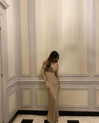 Robe longue longue scintillante, épaules dénudées, manches longues, en tissu brillant avec détails en sequins.