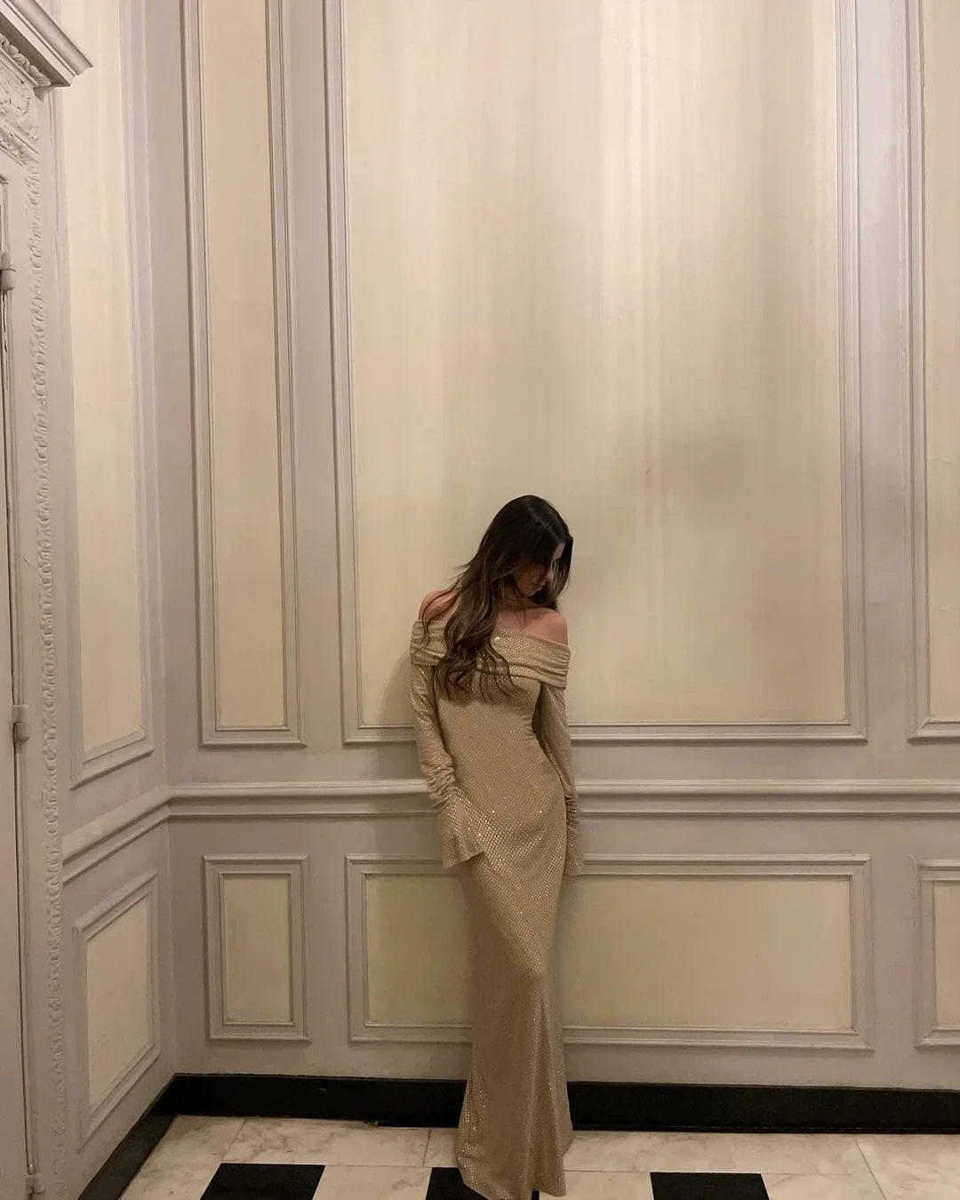 Robe longue longue scintillante, épaules dénudées, manches longues, en tissu brillant avec détails en sequins.