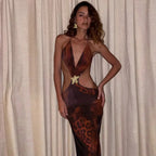 Robe longue marron en tissu fluide, coupe ajustée, détails dorés et découpes élégantes pour une soirée chic.