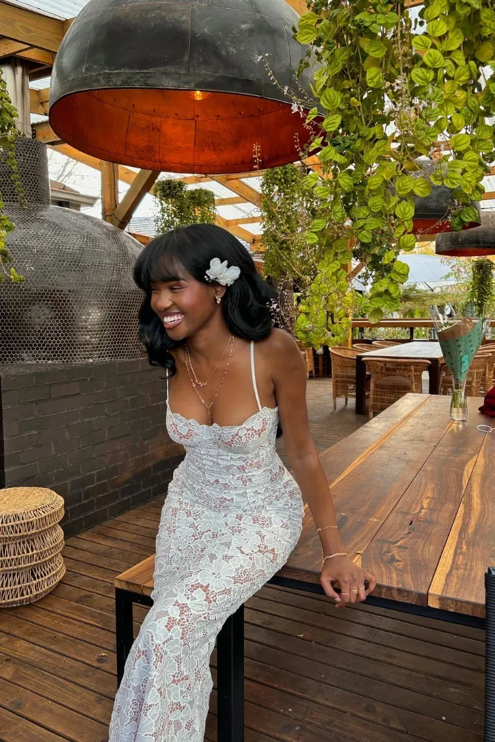 Robe longue en dentelle blanche, bretelles fines et col en cœur, parfaite pour un mariage ou une réunion estivale.