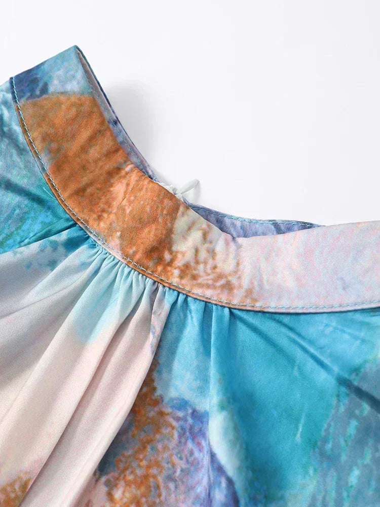 Robe longue plissée multicolore en tissu léger, manches longues, fronces à la taille pour un look élégant et fluide.