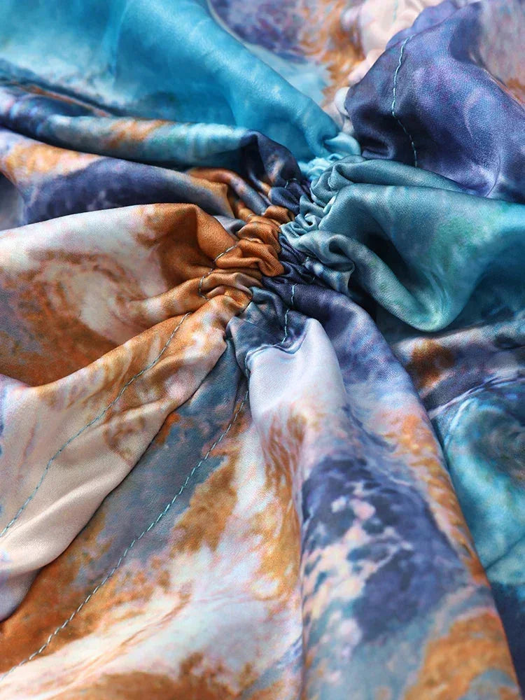 Robe longue plissée multicolore à manches longues, dotée de fronces et confectionnée en tissu léger pour une silhouette fluide.