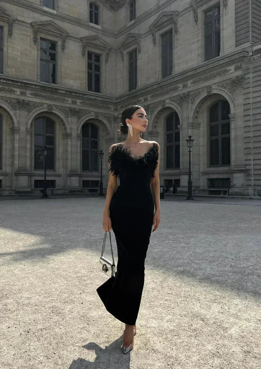 Robe longue noire sans bretelles en polyester, avec une élégante bordure en plumes pour une soirée chic.