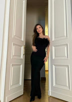 Robe longue noire sans bretelles en tissu léger, ornée d'une bordure en plumes pour une touche élégante. Ideal pour soirées.