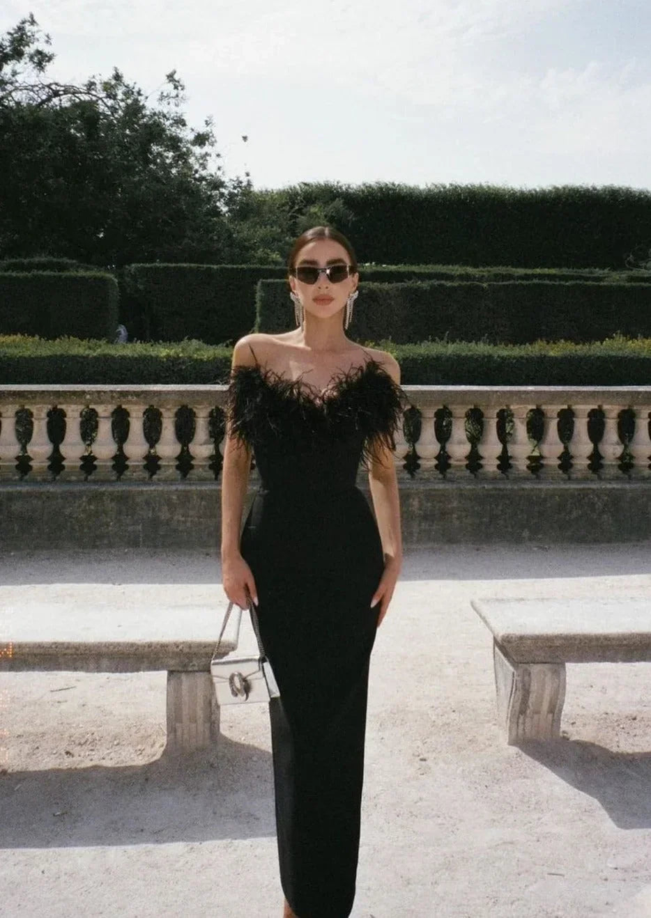 Robe longue noire sans bretelles en tissu léger, ornée de bordures en plumes pour un look élégant lors des soirées.