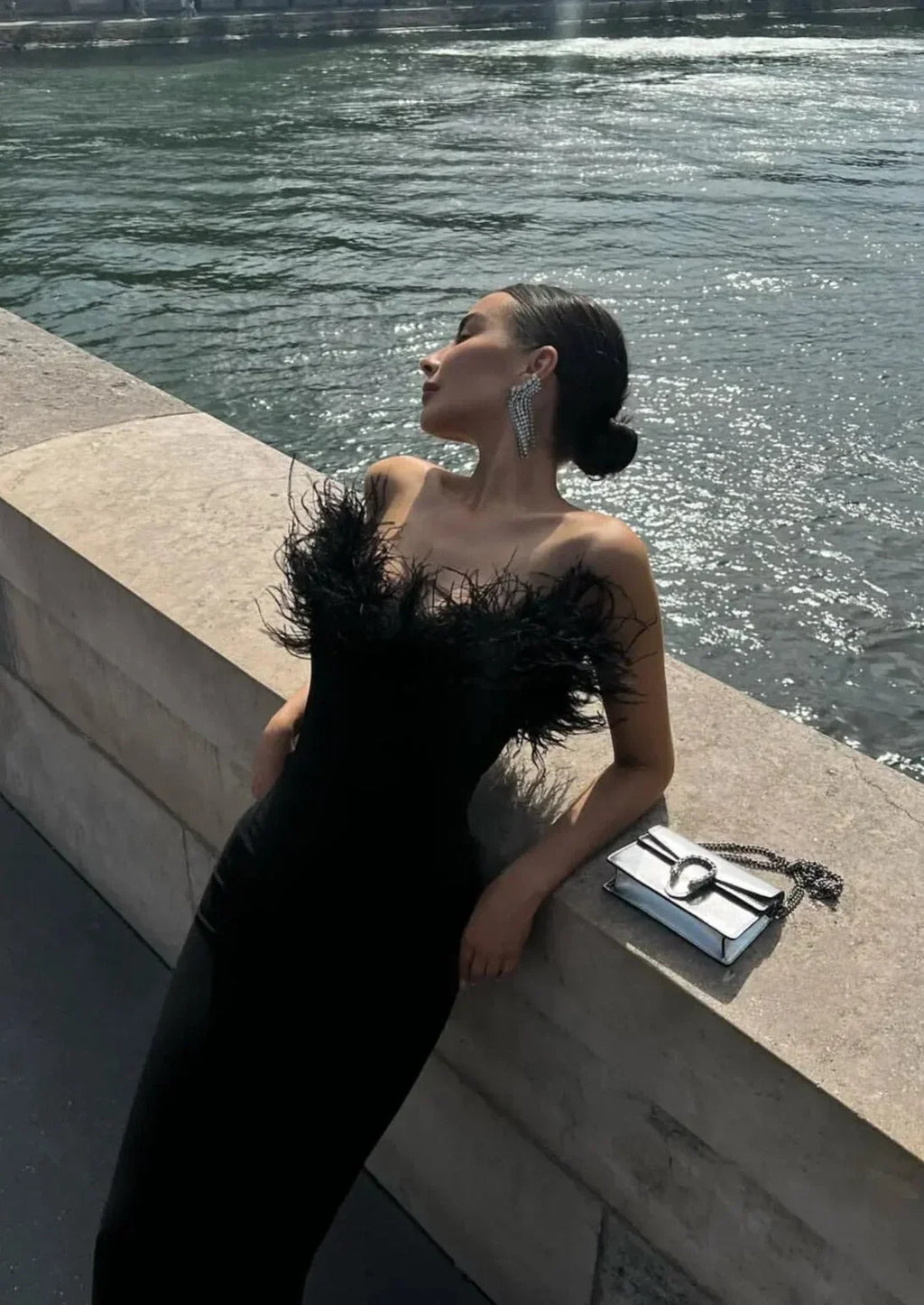 Robe longue noire sans bretelles, en tissu léger, avec une délicate bordure en plumes pour une allure élégante lors des…