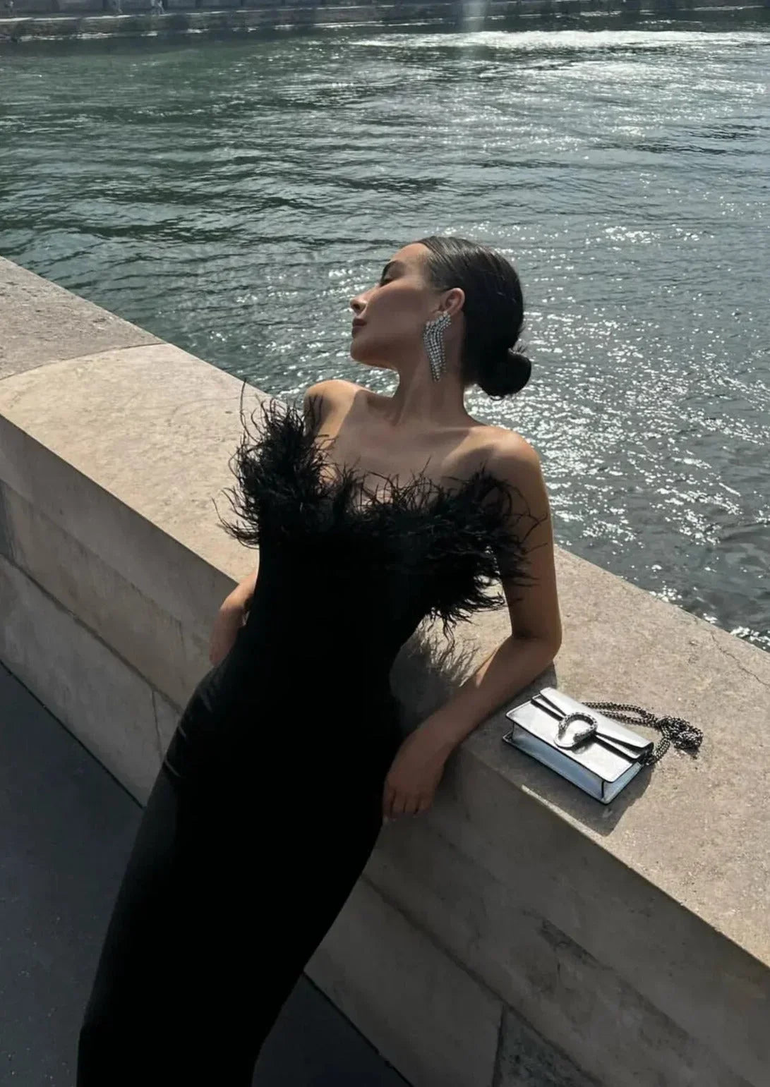 Robe longue noire sans bretelles, en tissu léger, avec une délicate bordure en plumes pour une allure élégante lors des…