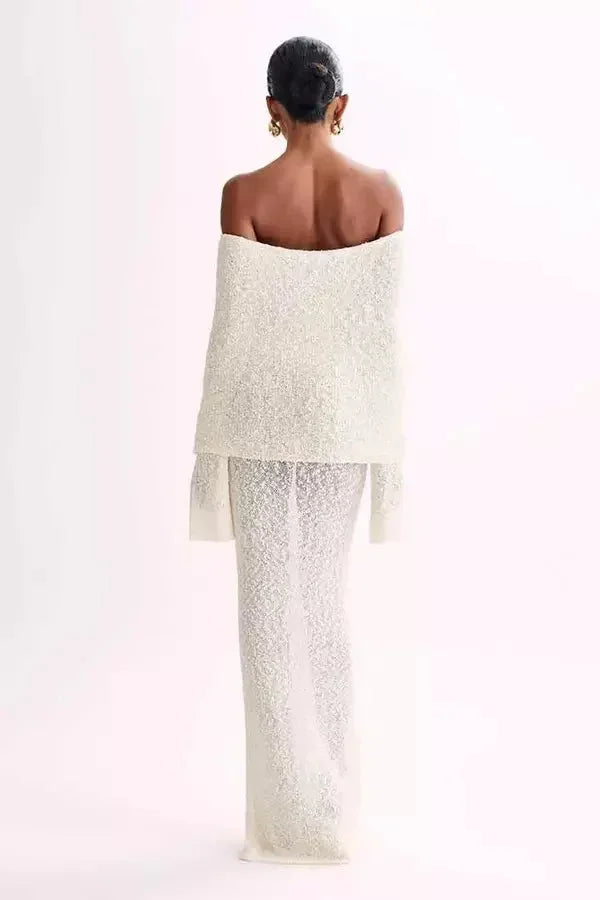 Robe longue à épaules dénudées en tissu texturé, avec manches longues et coupe fluide pour un style élégant et moderne.