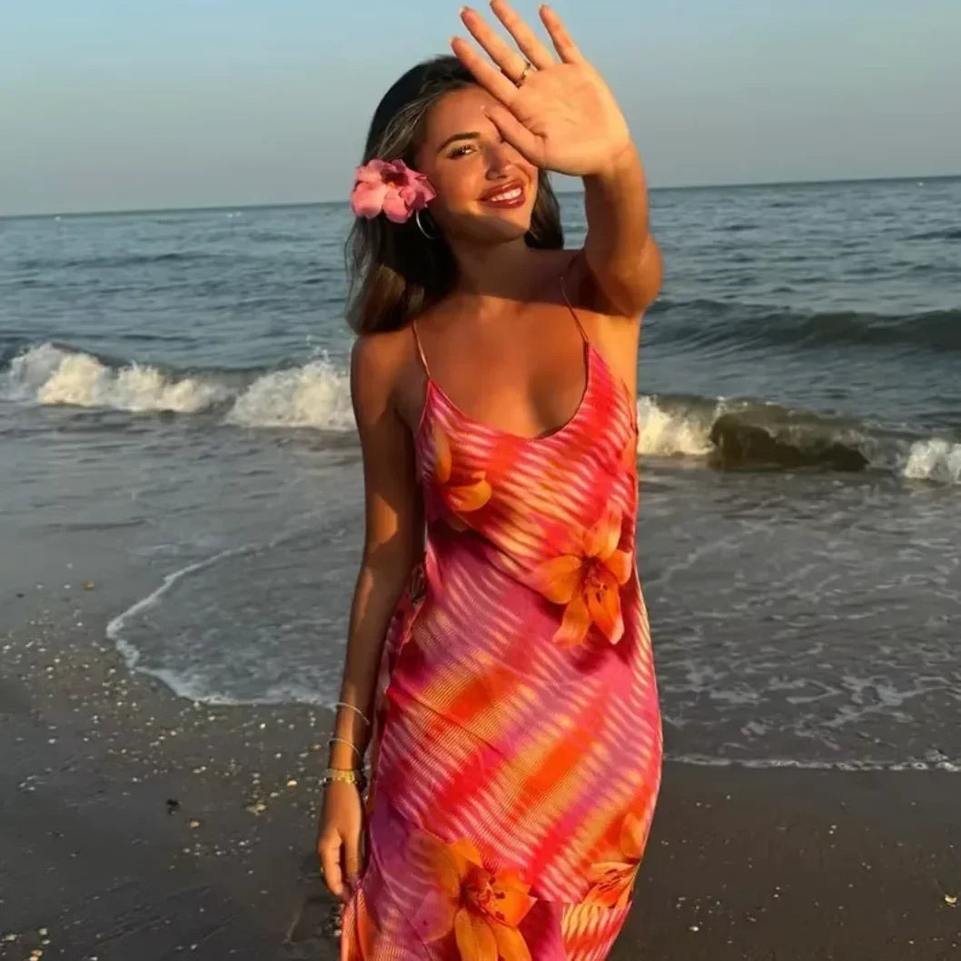 Robe longue plage fluide en tissu léger, imprimé tropical coloré, avec bretelles fines pour un style estival décontracté.