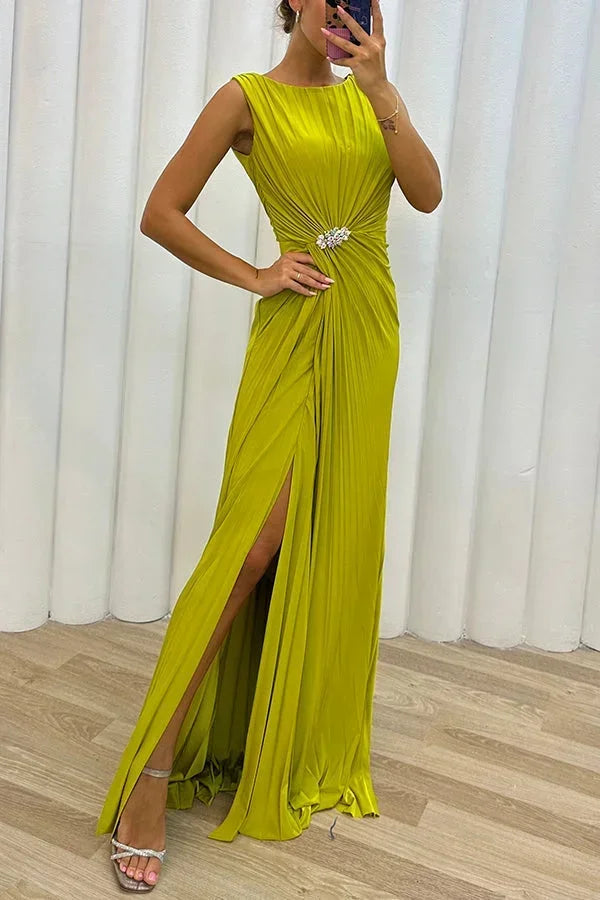 Robe longue plissée en chiffon, fente sur le côté, broche décorative et délicate, idéale pour des soirées élégantes.