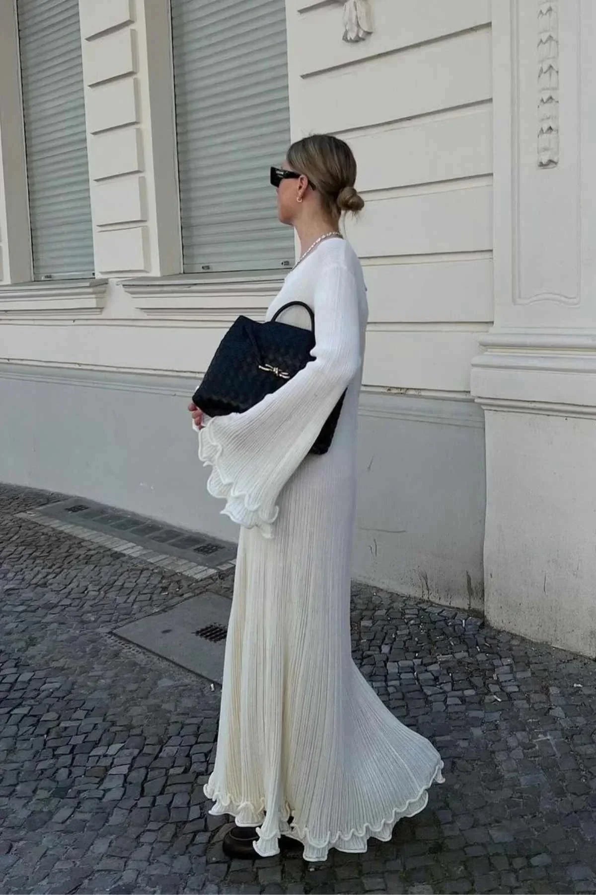 Robe longue plissée à manches longues évasées, col rond, en tissu texturé, idéale pour une soirée élégante.