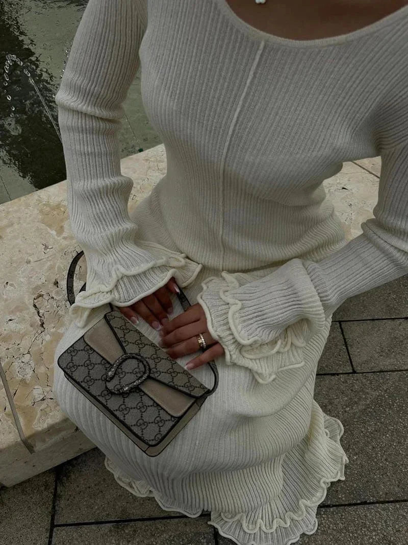 Robe longue plissée à manches longues évasées, col rond, en tissu texturé, idéale pour les soirées élégantes.