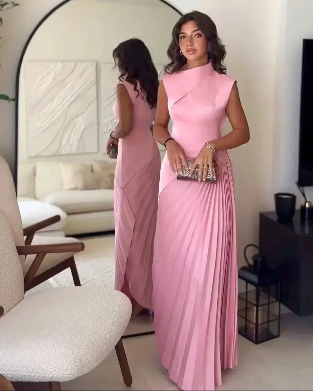 Robe longue plissée rose sans manches, en tissu léger, avec col asymétrique et finition fluide, parfaite pour l'été.