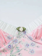 Robe longue rose à fleurs, bretelles fines, volants délicats, en tissu léger, idéale pour les journées d'été.