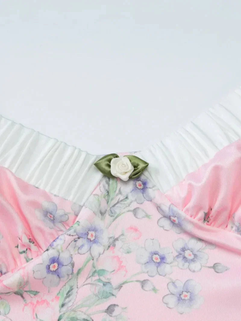 Robe longue rose à fleurs, bretelles fines, volants délicats, en tissu léger, idéale pour les journées d'été.