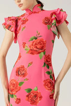 Robe longue rose avec motifs floraux, manches volantées et col haut, fabriquée en coton léger pour un confort optimal.