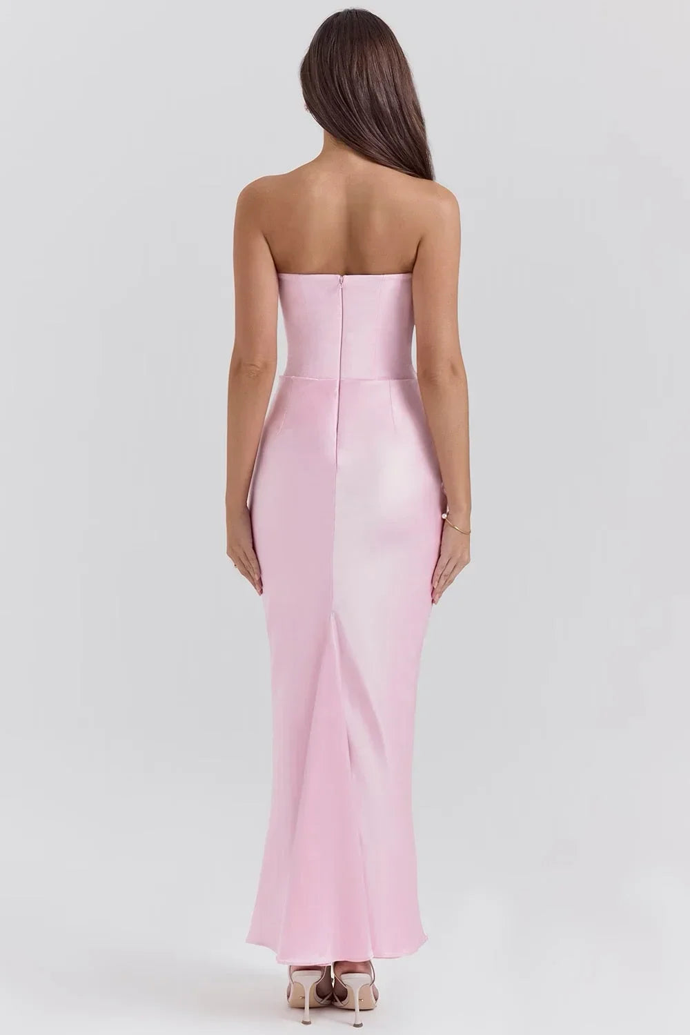 Robe longue rose sans bretelles en satin drapé avec bustier, offrant élégance et fluidité à chaque mouvement.