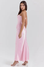 Robe longue rose sans bretelles en satin drapé, avec un bustier élégant et fluide pour une silhouette flatteuse.