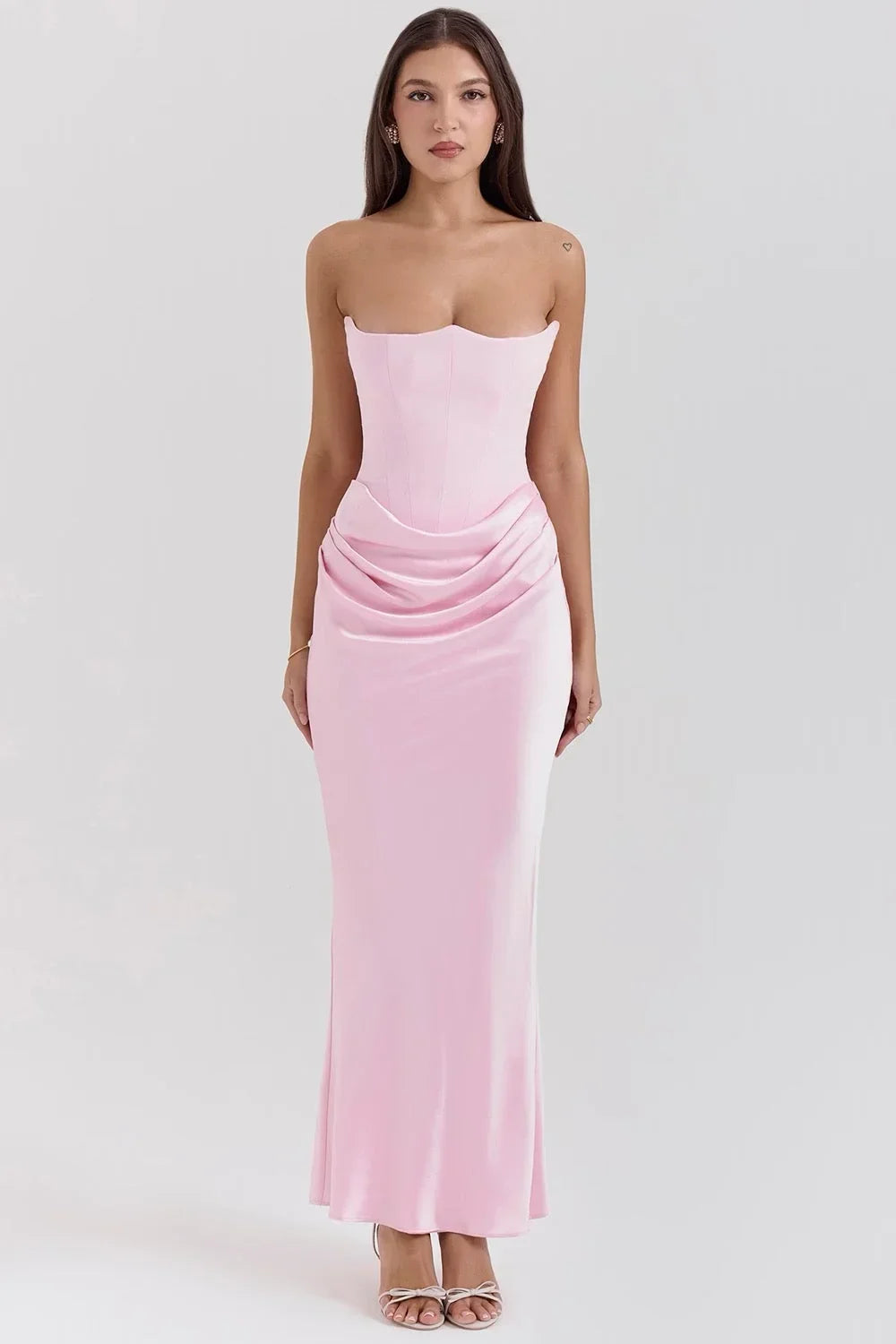 Robe longue rose sans bretelles en satin drapé, avec un bustier élégant idéal pour les occasions estivales.