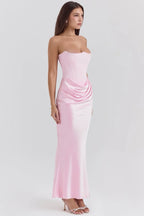 Robe longue rose sans bretelles en satin drapé avec bustier, offrant un look fluide et élégant pour toutes les occasions.
